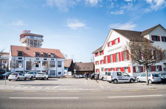 Das Roggwiler Dorfzentrum das Gasthaus Ochsen (rechts), der Parkplatz (links) und im Hintergrund der Kybun Tower. (Bild Andrea Stalder)